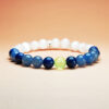 Aurora Turn crystal bracelet with white gypsum, blue aventurine, and grape agate for wealth, opportunity, and growth.