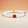 Aurora Ledger five element crystal bracelet with white jade, dumortierite, grape chalcedony, red agate, and yellow calcite for career and wealth.